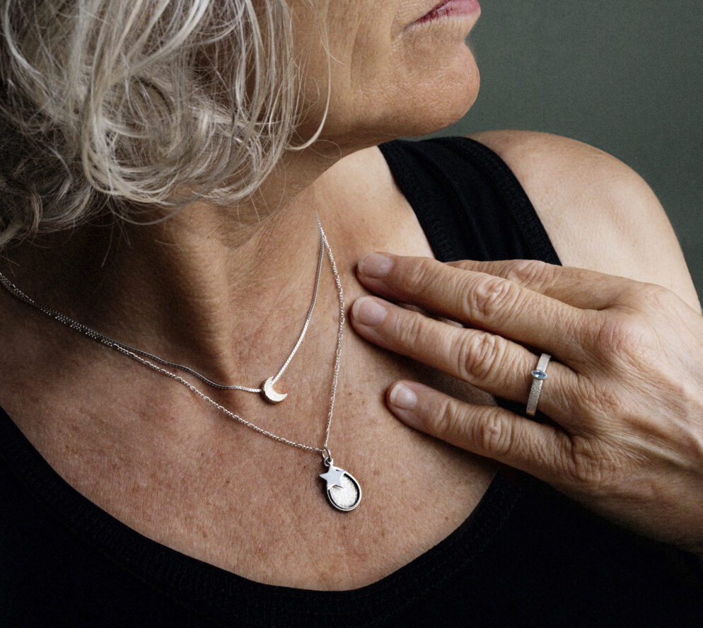 Elegante vrouw draagt gepersonaliseerde sieraden - kettingen en ring van Impona.