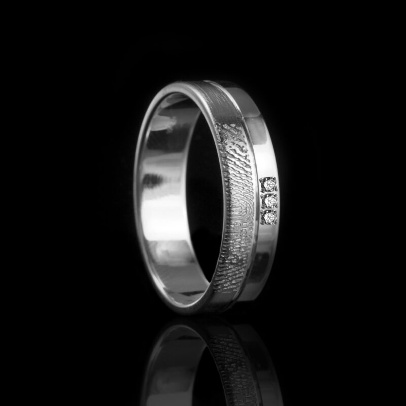 andgemaakte ring met subtiele vingerafdrukgravure en drie pavé gezette zirkonia's. Verkrijgbaar in hoogglans of matte afwerking, met een lichtbol profiel voor extra draagcomfort.