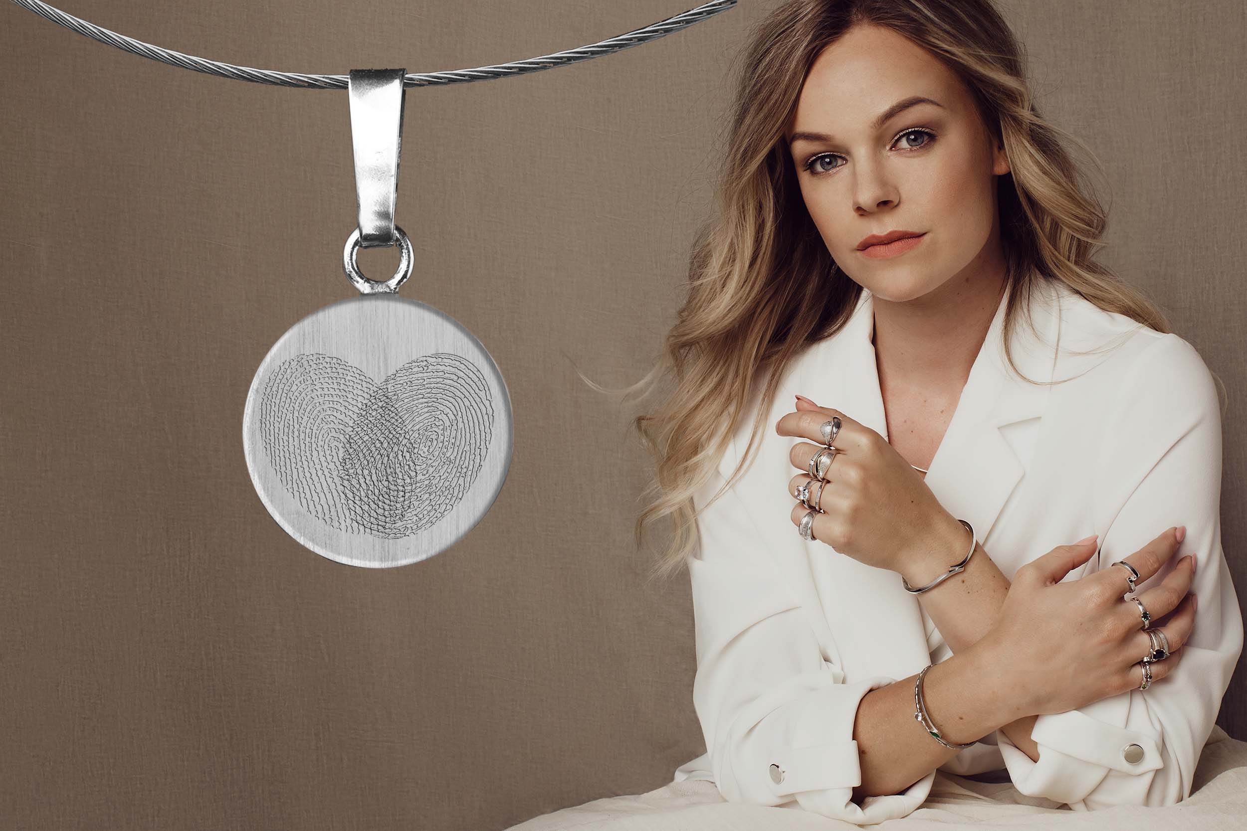 vrouw met vingerafdruksieraden met twee vingerafdrukken in een hartje