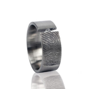 Vingerafdrukring met steen in klemzetting, handgemaakt in zilver of goud, met unieke gravure en elegante details.