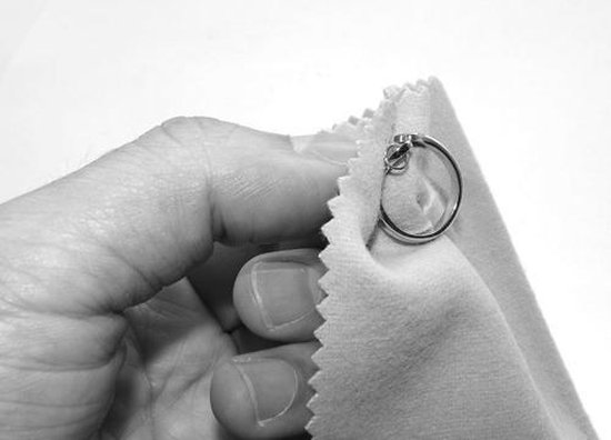 Zilveren herinneringssieraad verzorgen met zachte doek in het atelier